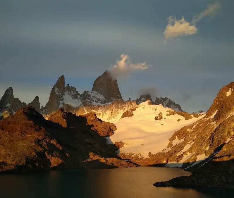 Stunning landscape of snow-capped Andes mountains and lake at sunrise in Argentina.